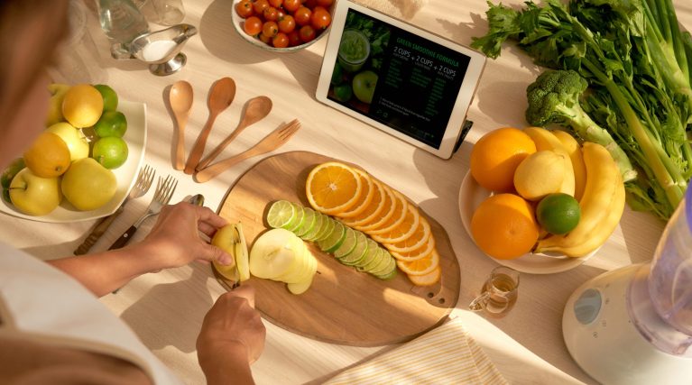 Woman cutting oranges, limes and apples in slices