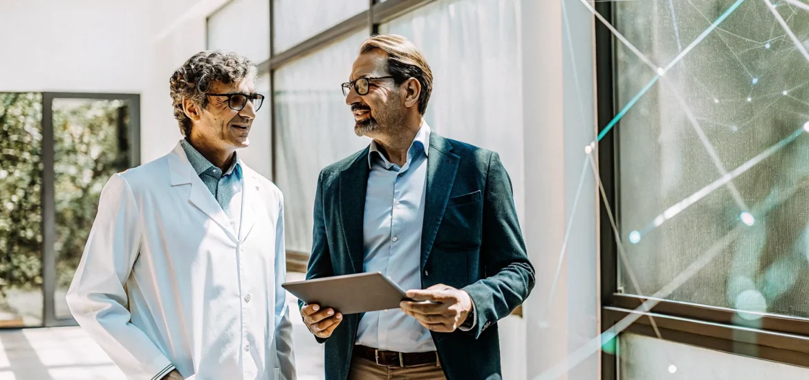 A doctor explains the benefits of testosterone therapy to a man using a tablet.